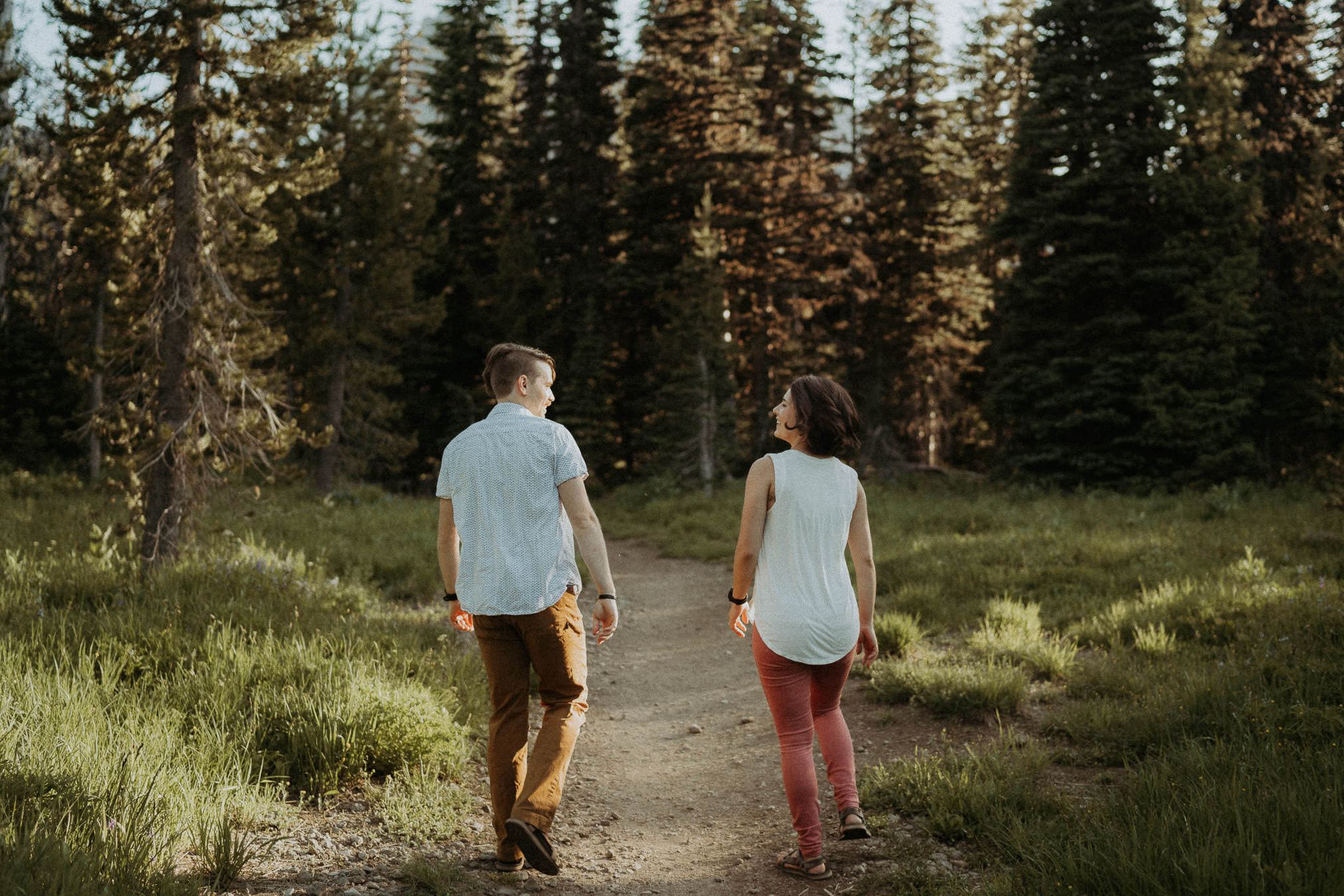 Larry and Alison walking hand in hand along a forest trail near Bend, Oregon